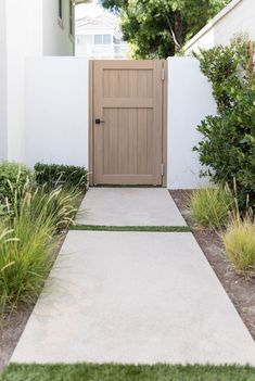 a white house with a wooden door and grass