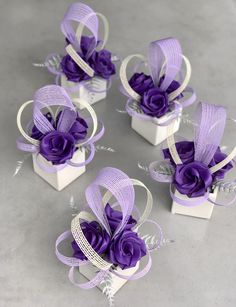 four small white boxes with purple flowers in them