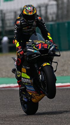 a man riding on the back of a motorcycle down a race track