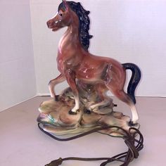 a horse figurine sitting on top of a table next to a charger