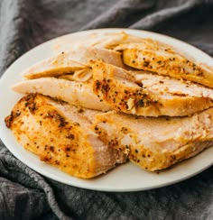 sliced chicken on a white plate with seasoning