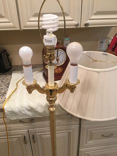 a lamp that is sitting on top of a table next to a light bulb and a clock