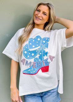 Step up your summer style in this playful Western boots graphic tee with 'America' sequin lettering embroidery. Perfect for Fourth of July festivities or just adding some fun and classic flair to your wardrobe. True to size Oversized fit intended Round neckline Pull on fit Sequin lettering embroidery Not lined 100% cotton Fabric has little stretch Casual Summer T-shirt With Embroidered Graphics, Summer Short Sleeve T-shirt With Embroidered Text, Comfortable Fit T-shirt With Text Print For Summer, Trendy T-shirt With Embroidered Text For Summer, Trendy Summer T-shirt With Embroidered Text, Comfortable Summer T-shirt With Graphic Print, Comfortable Fit Graphic Print T-shirt For Summer, Oversized Embroidered Tops For Summer, Oversized Casual Tops For 4th Of July