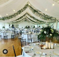 an indoor wedding reception with white linens and greenery