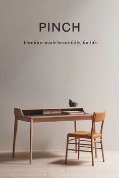 a wooden table sitting next to a chair on top of a hard wood floor under a sign that reads pinch furniture made beautifully, for life