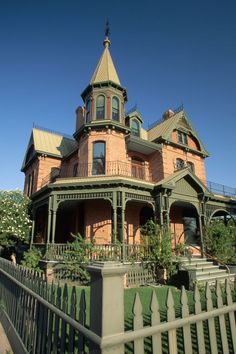 an old victorian style house with green trim