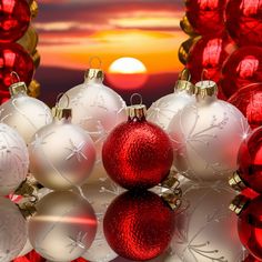 red and white christmas ornaments with the sun setting in the backround behind them