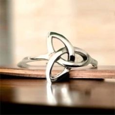 a silver ring sitting on top of a wooden table