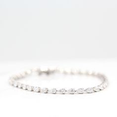 The Marquise Lab Grown Diamond Tennis Bracelet in white gold against a white background Gift Marquise White Gold Diamond Bracelet, White Gold Marquise Diamond Bracelet Gift, Gift Marquise Diamond Bracelet In White Gold, Marquise Diamond Bracelet In White Gold As A Gift, White Gold Diamond Bracelet Marquise Shape Gift, Classic Marquise Diamond Bracelet In White Gold, Classic Marquise White Gold Diamond Bracelet, Marquise Brilliant Cut Wedding Bracelets, Marquise Diamond Bracelet In White Gold