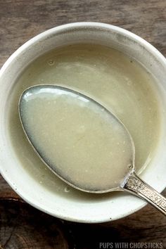 a white bowl filled with liquid and a spoon