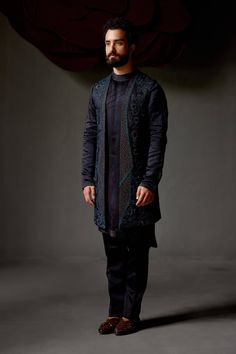 Editor's Note Featuring our midnight wane shrug set with the mastery of guipure-like embroideries and lace fluttering with a contrasting peacock green thread. Paired with a matching shoulder button embroidered kurta and tapered trousers. Fabric: Linen silk Color: Blue Components: Shrug, kurta, trousers Occasion: Wedding guest Fit: Regular Note: Product colour may slightly vary due to photographic lighting sources Care: Dry clean only About the Designer After establishing himself as the leading c Fitted Kurta With Embroidered Sleeves And Traditional Drape, Festive Sets With Embroidered Sleeves And Traditional Drape, Festive Fitted Sherwani With Embroidered Sleeves, Fitted Sets With Embroidered Sleeves For Festive Season, Fitted Kurta With Set-in Sleeves For Wedding, Fitted Wedding Kurta With Set-in Sleeves, Black Sets With Embroidered Sleeves For Eid, Fitted Sets With Embroidered Sleeves For Eid, Festive Fitted Set With Embroidered Sleeves