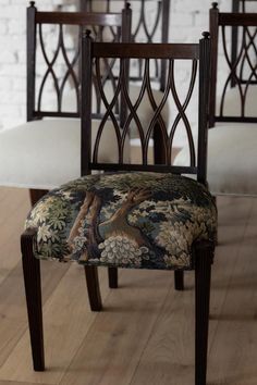 a set of four chairs with floral upholstered back and seat covers on wooden floors