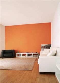 a living room with orange walls and white furniture