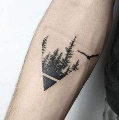 a man's arm with trees and an eagle tattoo on the left side of his arm