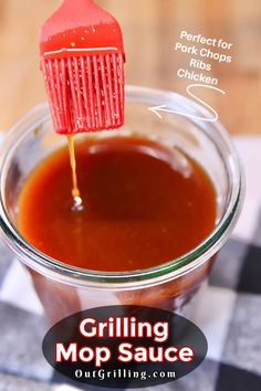 a jar filled with sauce on top of a checkered table cloth