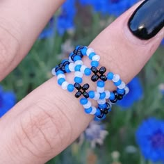 a woman's hand with blue and white beaded bracelets on her wrist