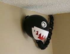 a balloon shaped like a shark hanging on the wall with chains around it's mouth