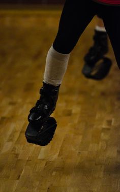 the legs and feet of a person in roller skates on a wooden floor with wood floors