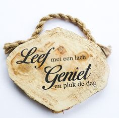 a piece of wood with the words let met een lach geniet en pluk de dag on it