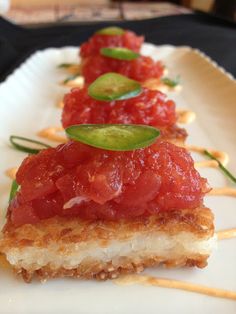 three pieces of food on a plate with toothpicks and garnishes