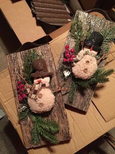 two snowmen sitting on top of wooden boards