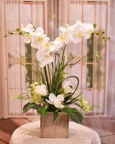 a vase filled with white flowers on top of a table