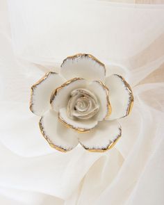 a white flower with gold accents on it