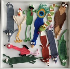 several knitted toys are arranged in a tray