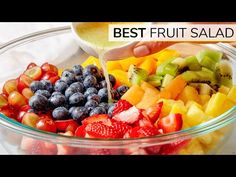 the fruit salad is being made in a glass bowl