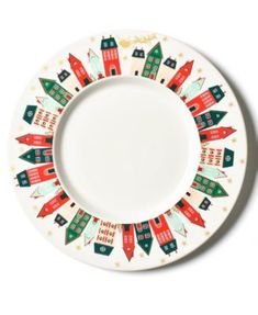 a white plate with red and green houses painted on it's rim, against a white background