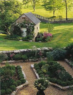 a small house surrounded by lush green grass and flowers in the middle of a garden