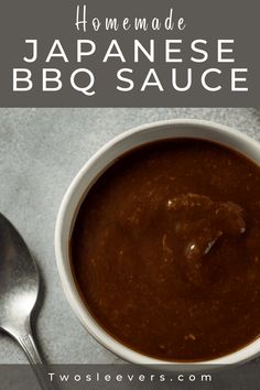 a bowl of bbq sauce next to a spoon on top of a gray surface