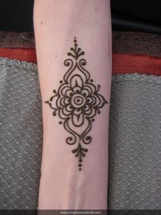 a person's foot with a henna tattoo on the left side of their leg