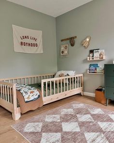 a baby's room with a crib, dresser and rug in the corner