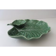 a green leaf shaped bowl sitting on top of a table