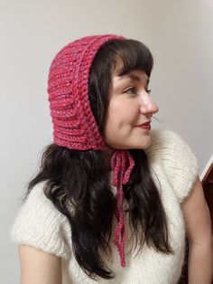 a woman wearing a pink knitted hat and scarf