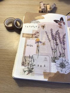 an open book with flowers and butterflies on it, next to some tape dispensers