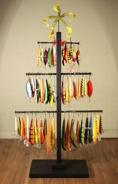 a christmas tree made out of different types of fishing lures on a black stand