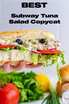 A Subway Tuna Salad Sandwich Copycat being held in the air above a tomato, some lettuce and onions. Copycat Kmart Sub, Copycat Subway Tuna, Best Tuna Salad Recipe Sandwiches, Tuna Salad Croissant Sandwich, Subway Tuna Recipe, Subway Tuna Sandwich, Tuna Sub Sandwich, The Best Tuna Salad Recipe, Simple Tuna Recipes