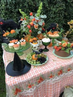 a table topped with cakes and desserts on top of a checkered table cloth