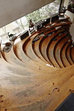 a large wooden boat sitting on top of a floor next to a window in a building