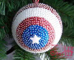 an ornament hanging from a christmas tree with red, white and blue beads