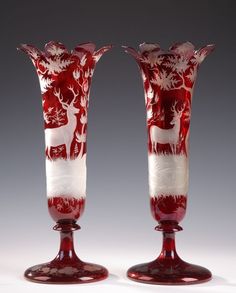 two red and white glass vases sitting next to each other