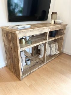 an entertainment center made out of pallets with a flat screen tv mounted on the wall