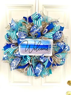 a blue and white welcome wreath on a door