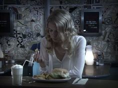 a woman sitting at a table with a plate of food