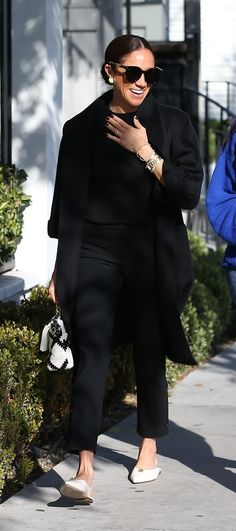 a woman walking down the street wearing black