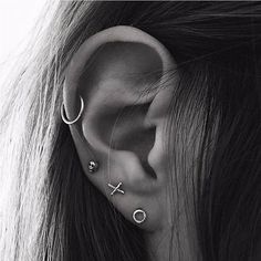 a woman with ear piercings in the shape of an x on her left ear