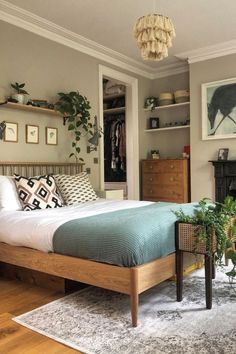 a bed sitting in a bedroom next to a wooden dresser under a hanging planter