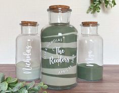 three glass bottles with labels on them sitting on a table